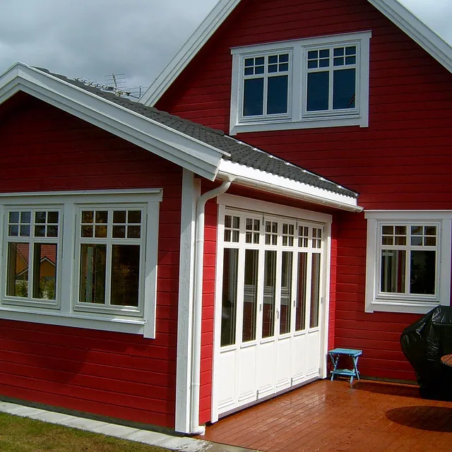 Rødt hus med hvite vinduer og sprosser