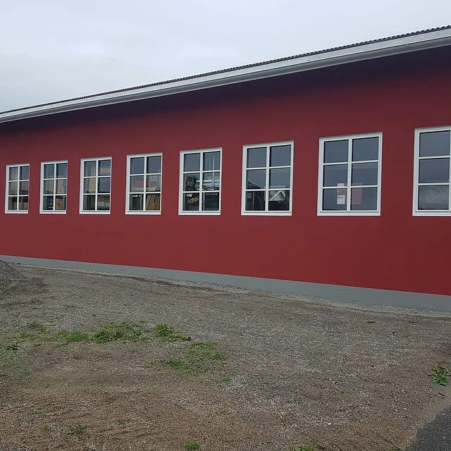 Lang rød husvegg med hvite sprosser